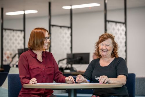 A Housing Officer and customer sit together and chat.