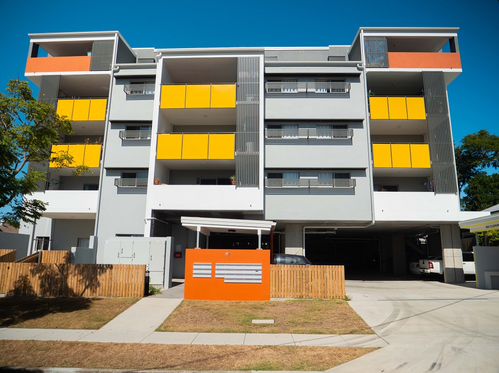 View from the street, showing the 5-storey building with bright feature balconies to the front.